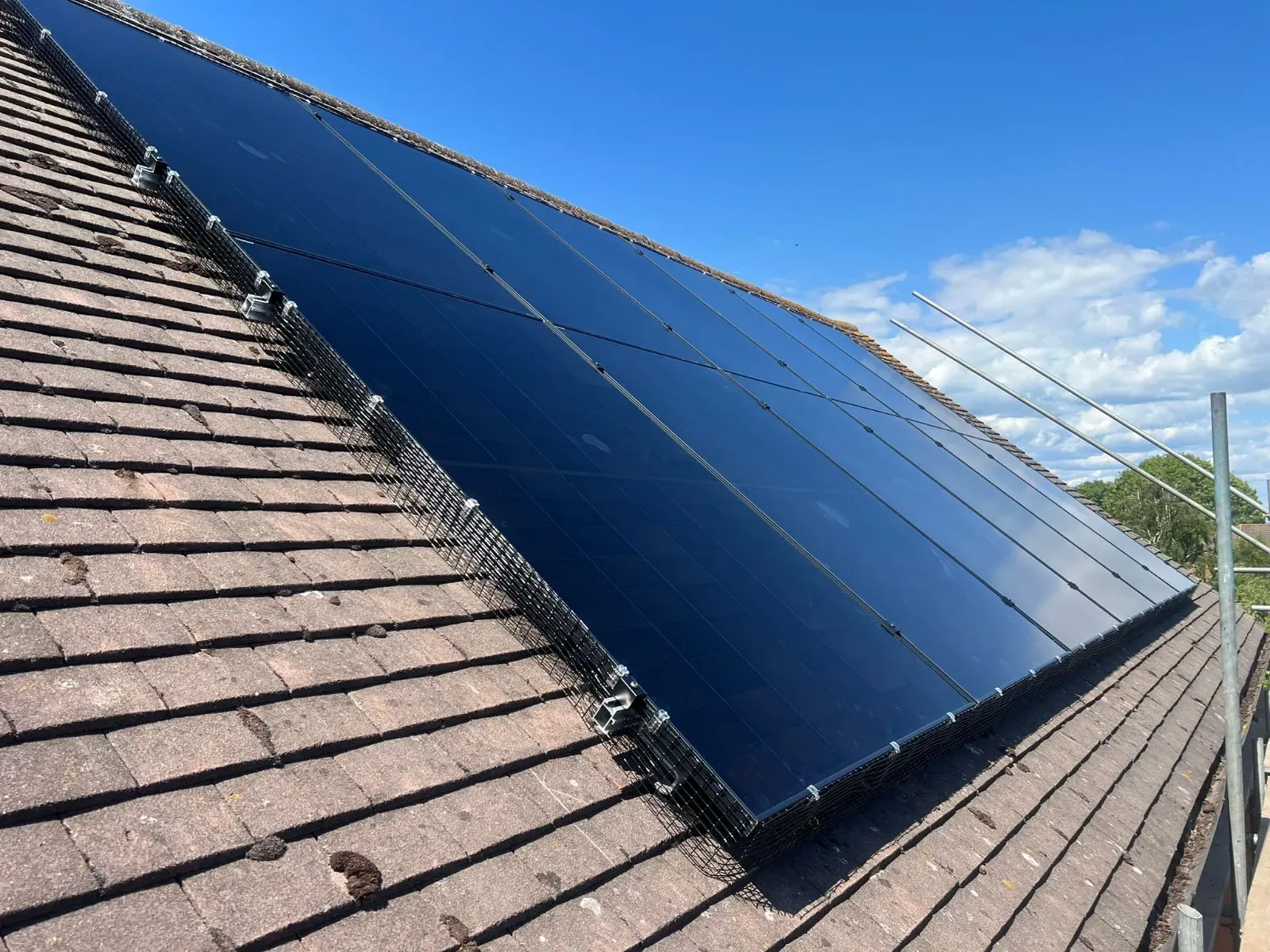 Solar panels on a tiled roof under a blue sky