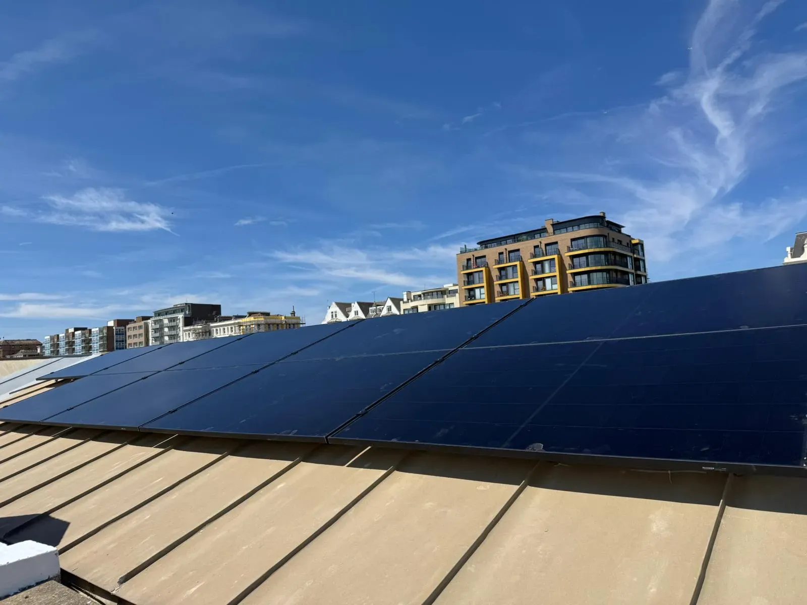 Solar panels on a flat roof with apartment blocks behind