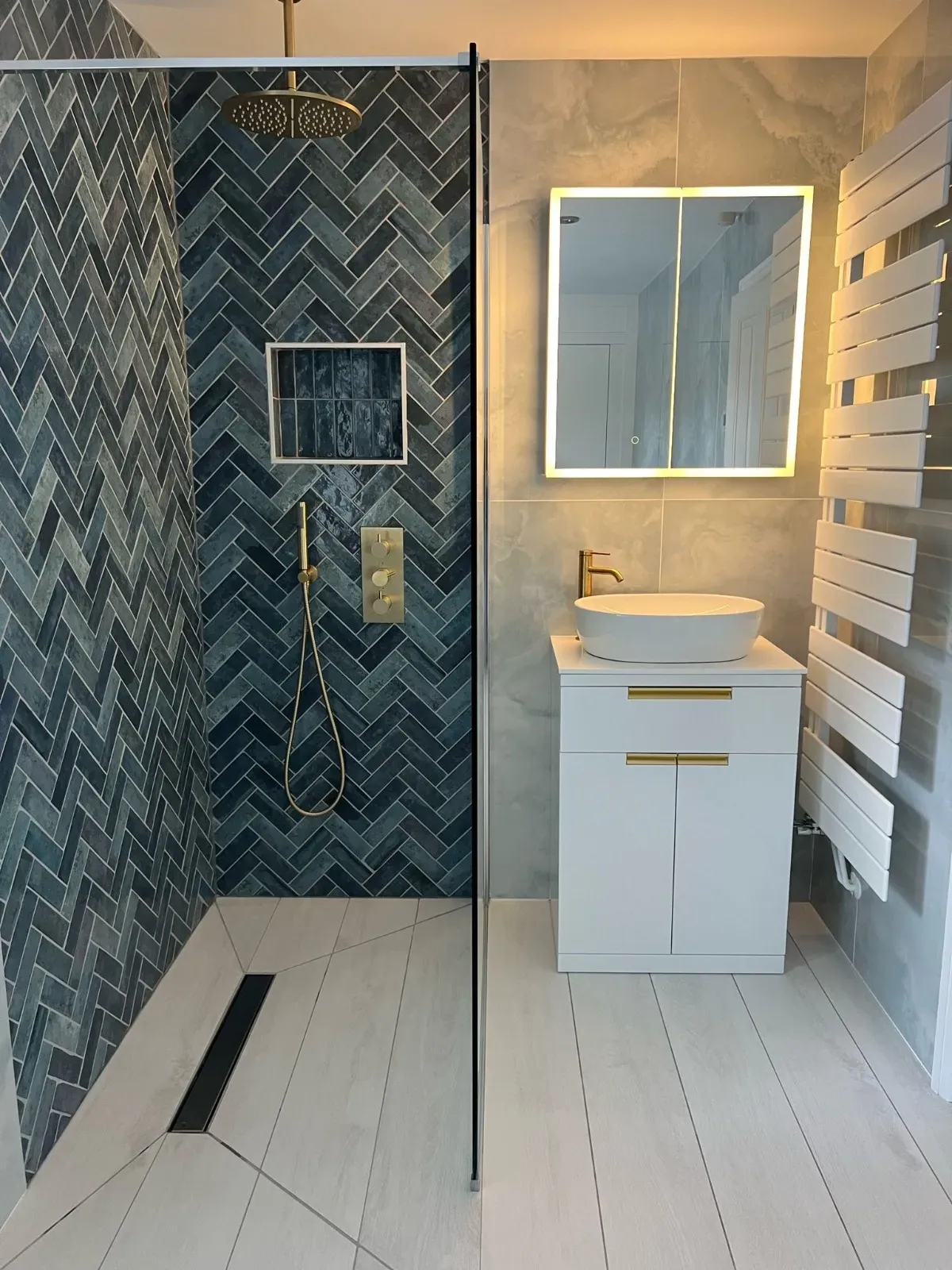 A finished bathroom with a walk-in shower and patterned tiles