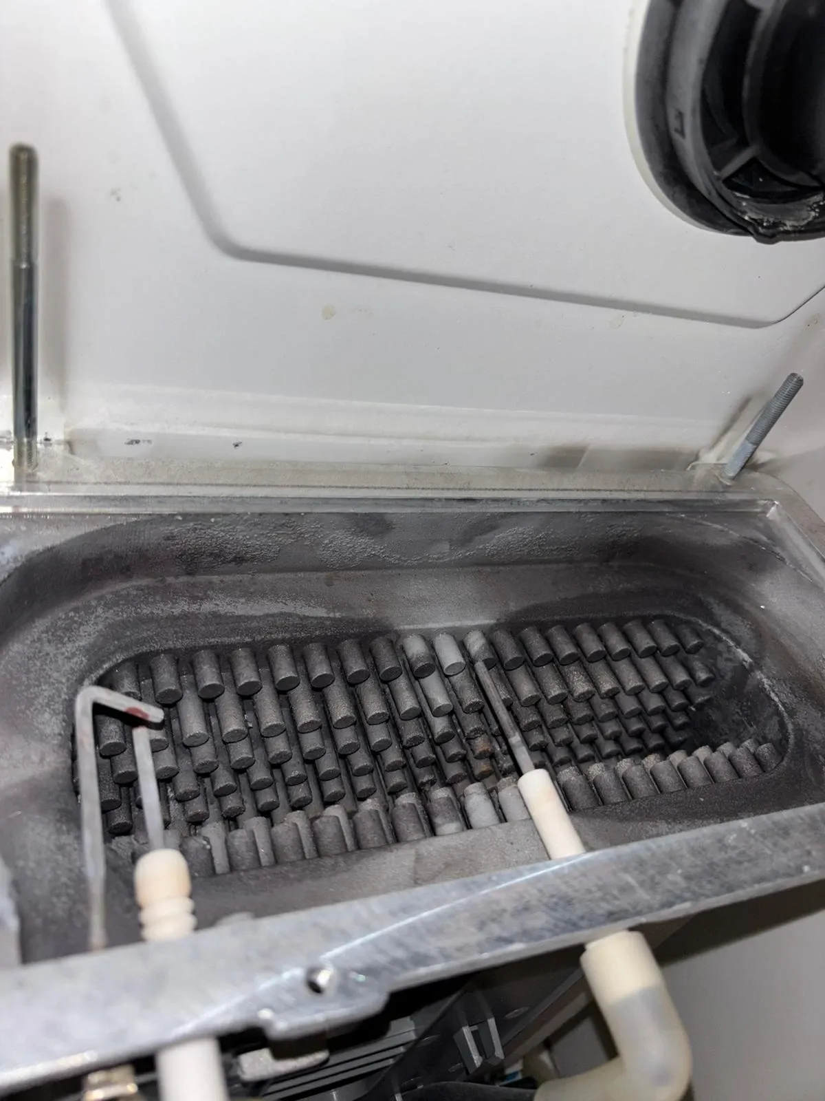 A boiler heat exchanger before cleaning, heavy with scale and soot